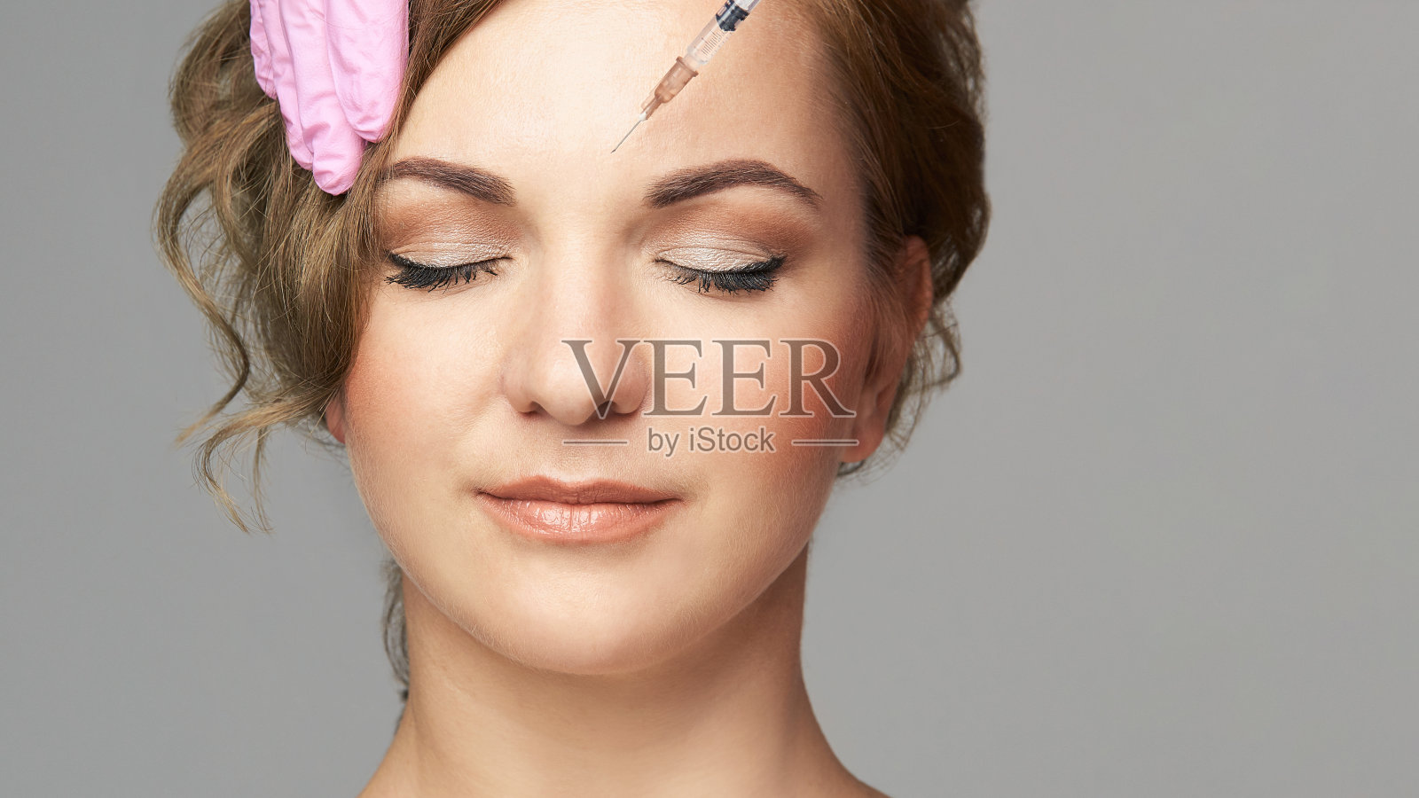 面部针注射。年轻女性美容手术。医生手套。皱纹照片摄影图片