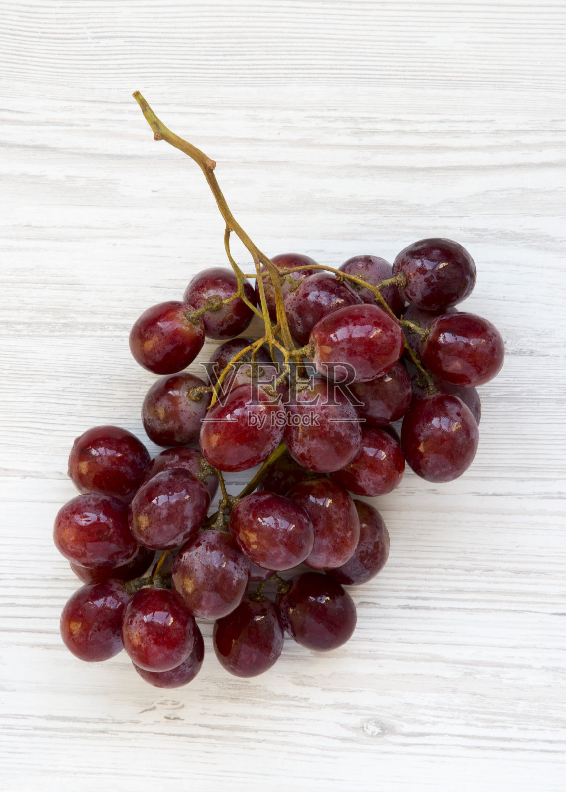 白木桌上放一串成熟的红葡萄，俯视图。开销,从上面。照片摄影图片