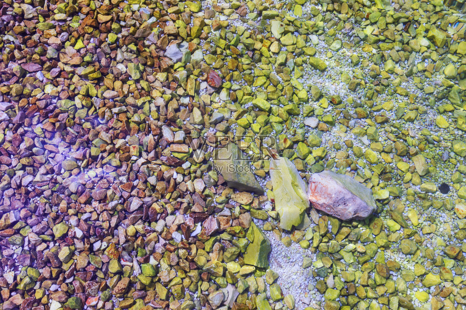 石头在水里。海滩上的海卵石。海卵石上的沙滩上有透明的水。天然海石特写。海滩上光滑的鹅卵石。旅游旅游主题。假期的背景。照片摄影图片