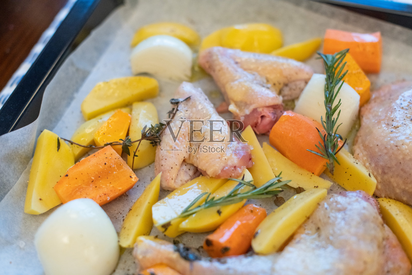准备烤鸡翅、鸡腿及蔬菜。概念烘焙，生食。照片摄影图片