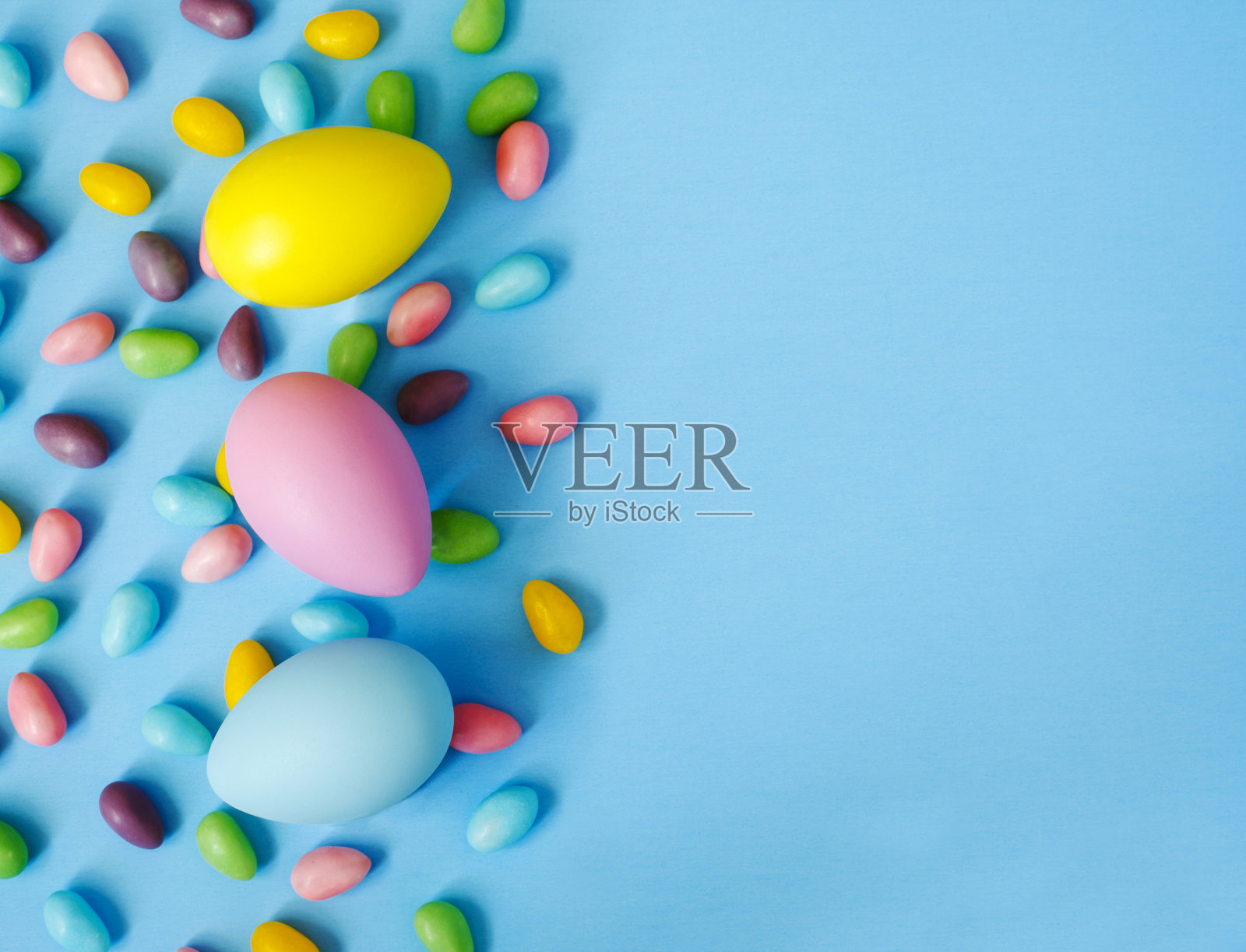 复活节装饰彩蛋和糖果在蓝色的背景。复活节的背景照片摄影图片