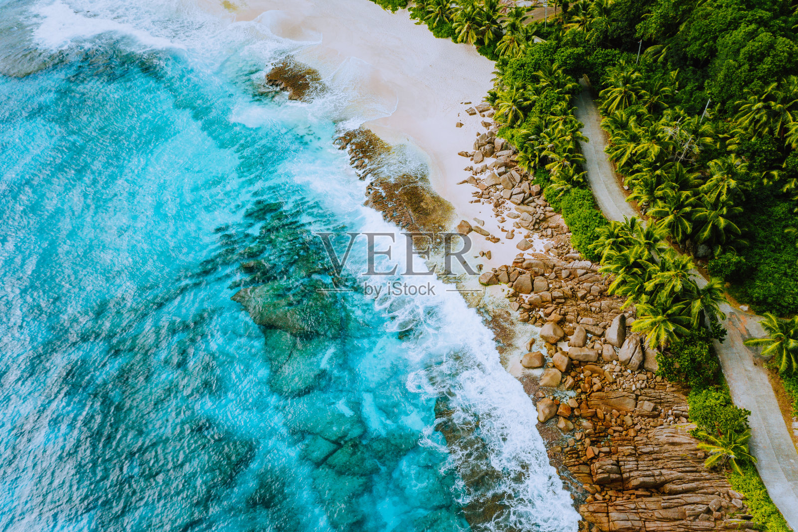 塞舌尔马埃岛无人机景观的海岸线天堂般的沙滩与棕榈树和美丽的清澈的蓝色海浪翻滚的花岗岩。浅梦幻的湖照片摄影图片