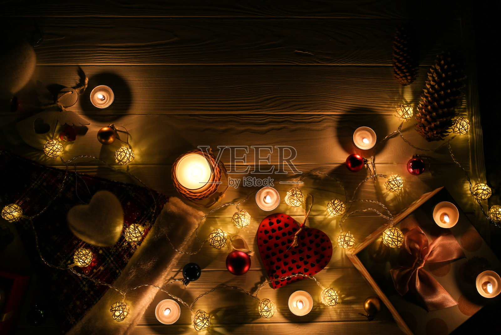 蜡烛在美丽的圣诞彩灯和花环装饰中燃烧。新年喜庆的背景。礼物，礼物，寒假贺卡。照片摄影图片