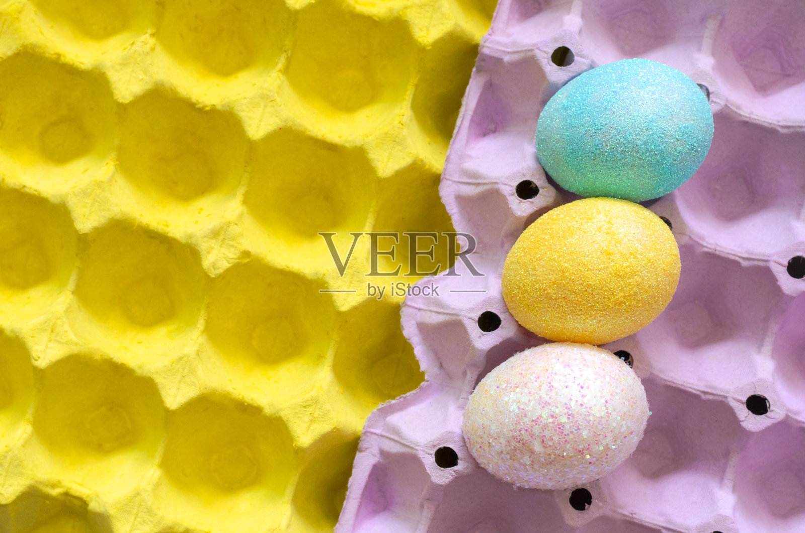 复活节和节日用亮片装饰多彩的蛋放在蛋盘里。照片摄影图片