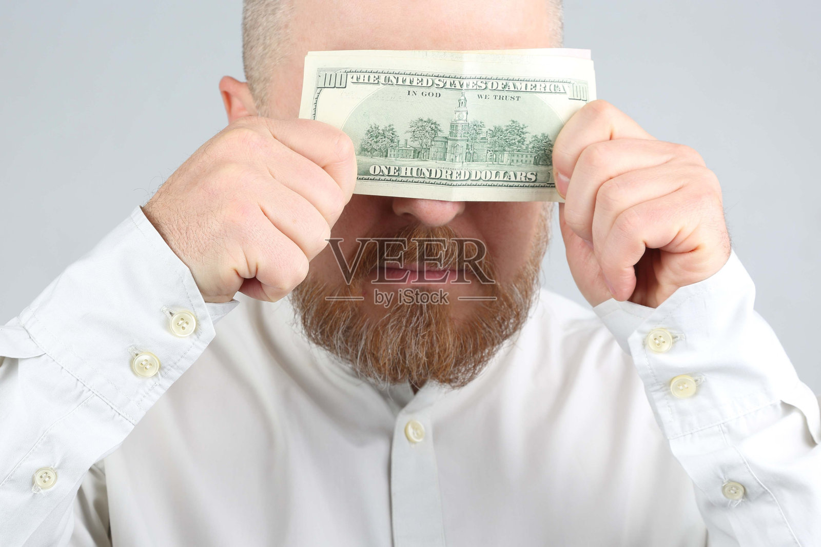 大胡子男子用脸合上一美元照片摄影图片