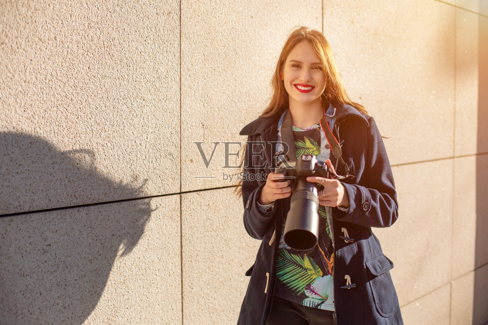 快乐的女人度假摄影与相机在城市街道上。太阳耀斑照片摄影图片