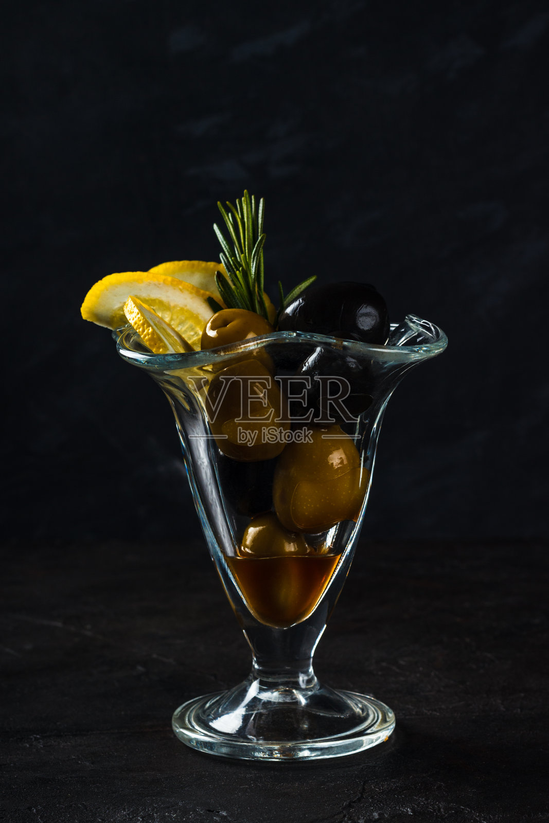 绿色黑橄榄，柠檬和一枝迷迭香作为零食照片摄影图片