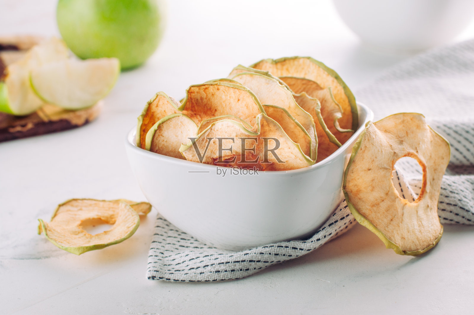 干苹果片放在白色陶瓷碗里照片摄影图片