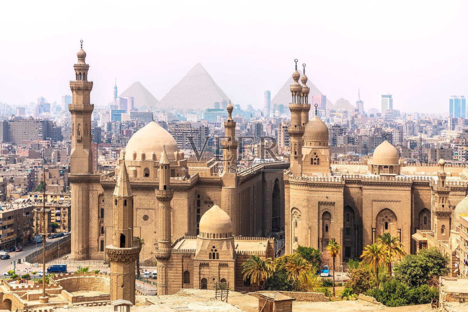 背景是苏丹哈桑的清真寺和金字塔，埃及开罗照片摄影图片
