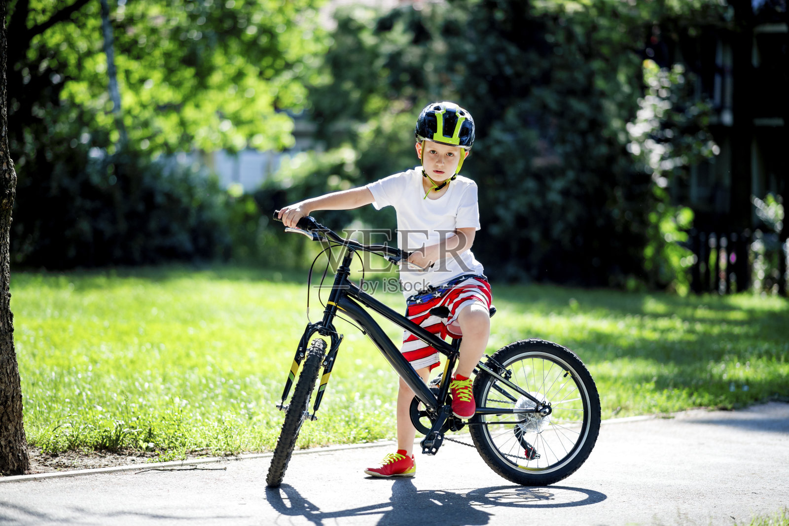 小男孩在公园里骑自行车照片摄影图片