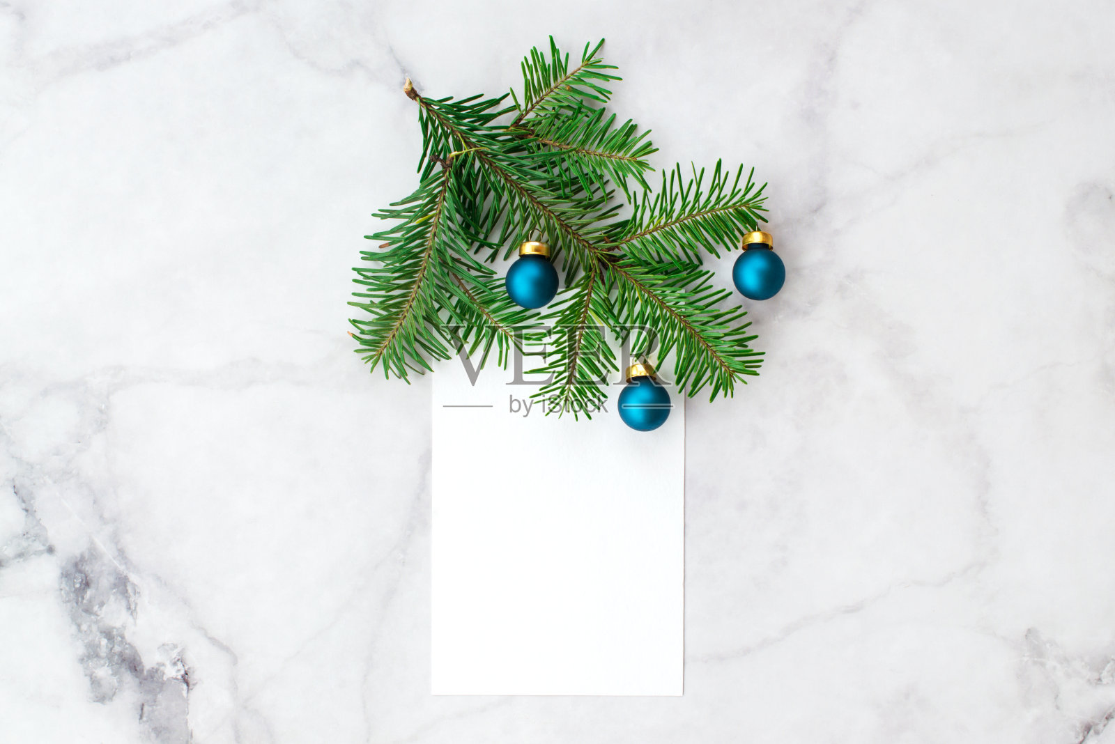 灰大理石背景上装饰着蓝色小球的冷杉树枝。新年、圣诞节和冬天的概念。平铺，俯视图，自由拷贝空间。照片摄影图片
