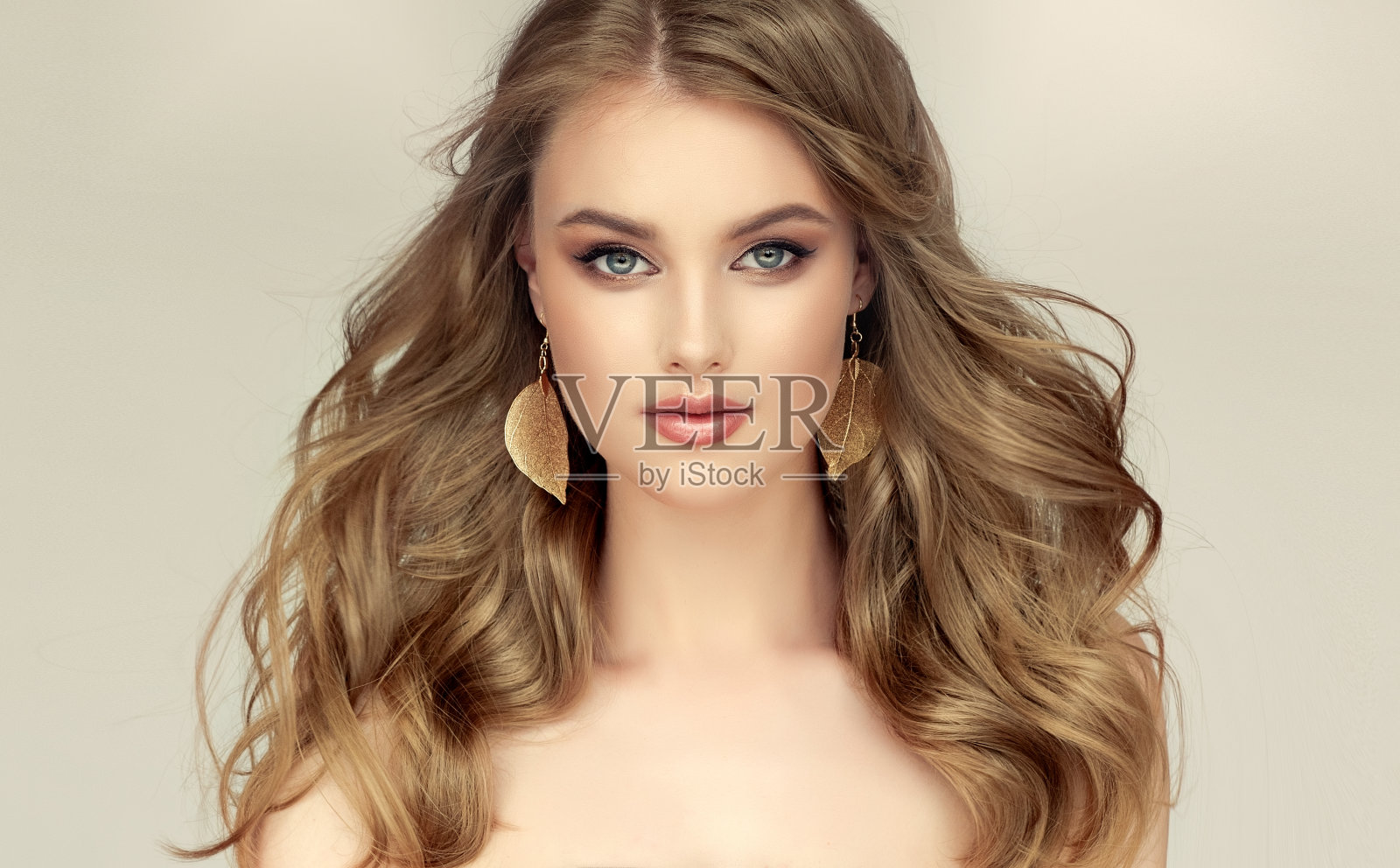 肖像的金发模型与长，密集，自由地放置发型和整洁的化妆。照片摄影图片
