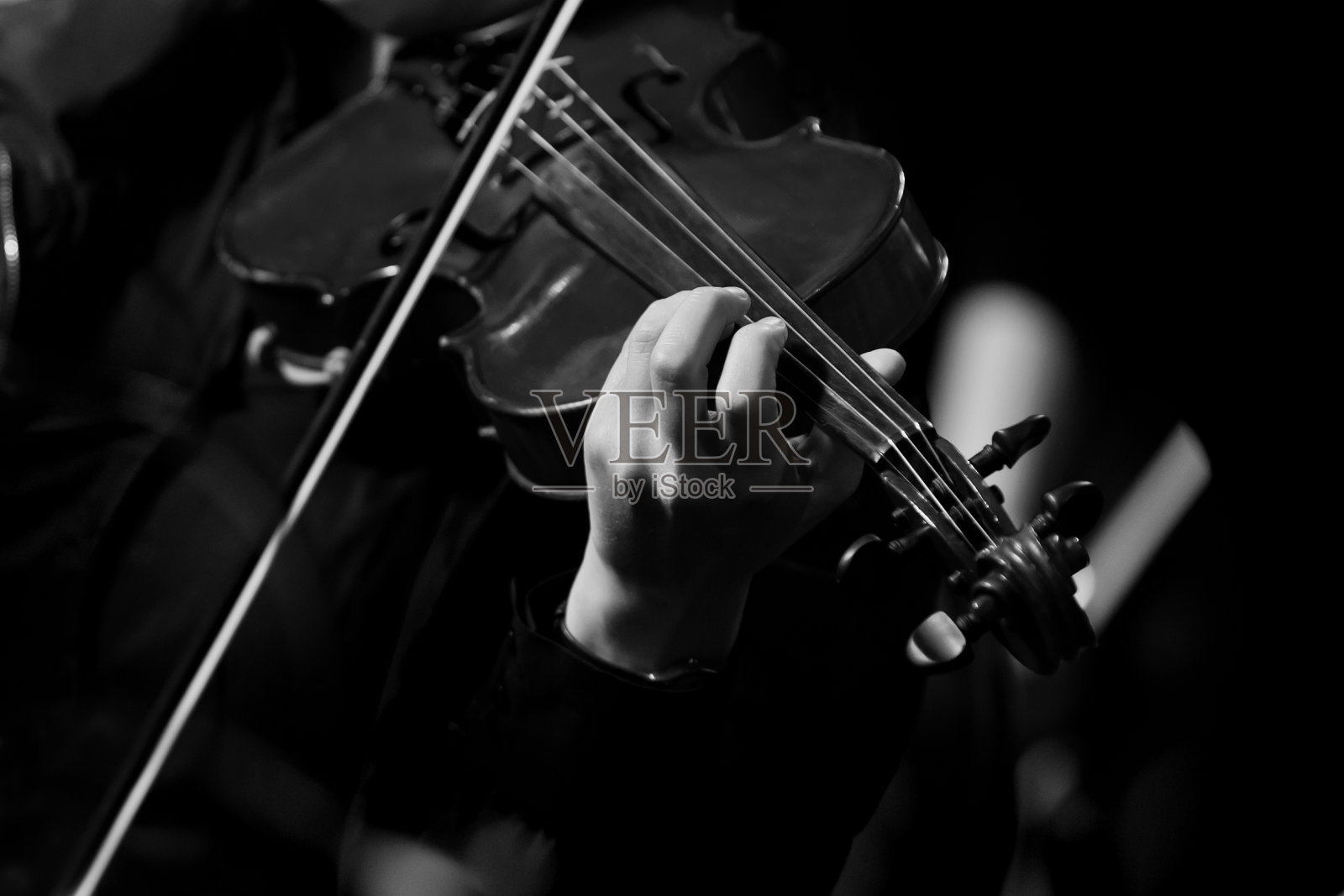 音乐家的手放在小提琴弦上照片摄影图片
