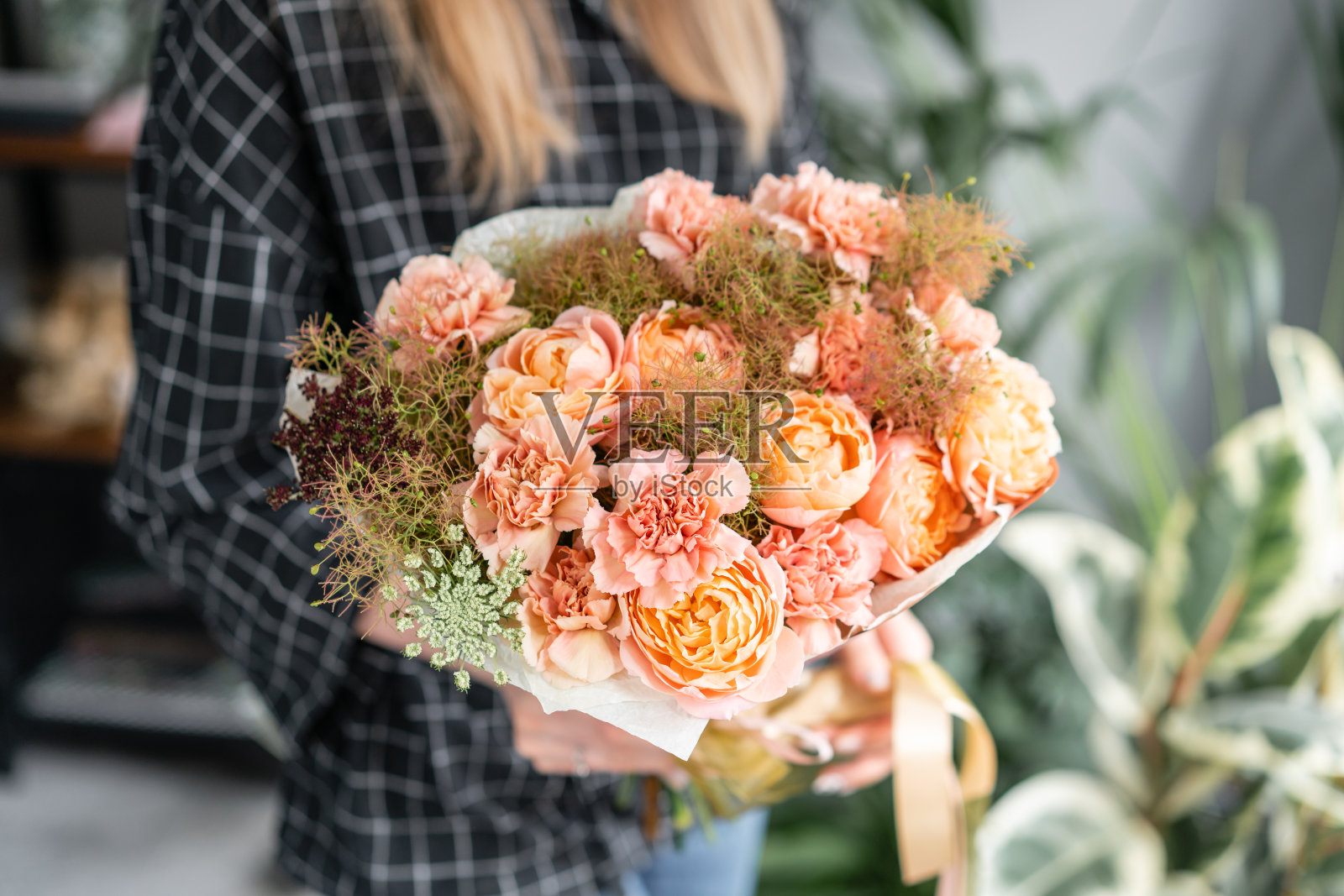 女人手里拿着一束美丽的混合鲜花。花店概念。英俊的新鲜的花束。花交付。照片摄影图片