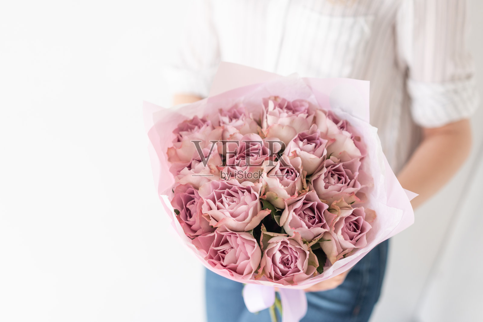 一束玫瑰。女子手中精致的混合鲜花。花店花匠的工作。精致柔和的颜色。新鲜切花。照片摄影图片