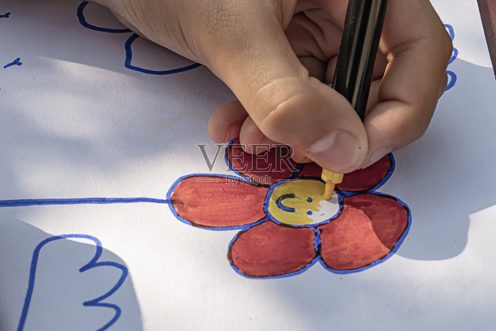 小女孩正在画一幅彩色的花照片摄影图片