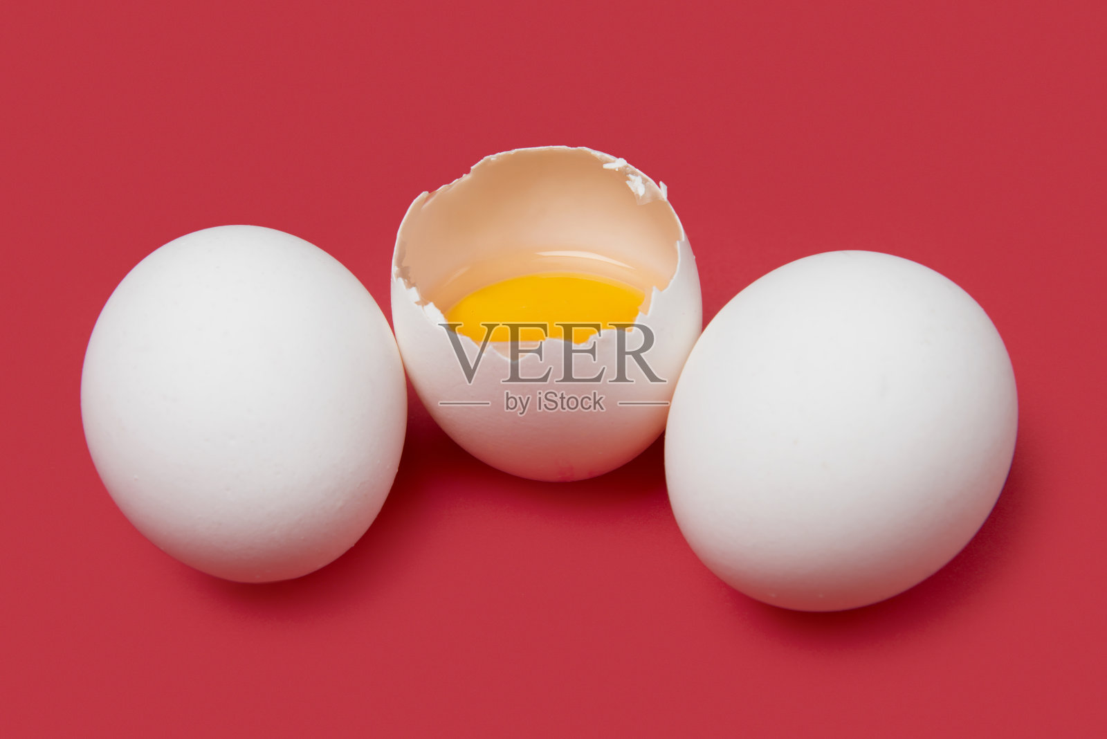 高角度的小组白色生鸡蛋，一个是破碎的粉红色背景照片摄影图片