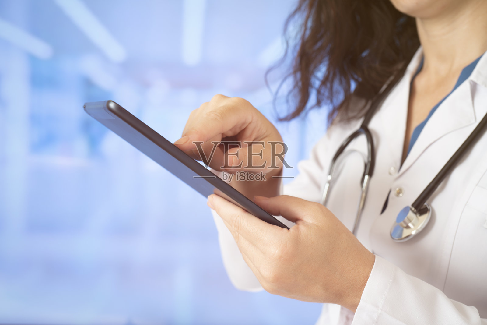 女医生在医院里笔直地站着使用平板电脑照片摄影图片