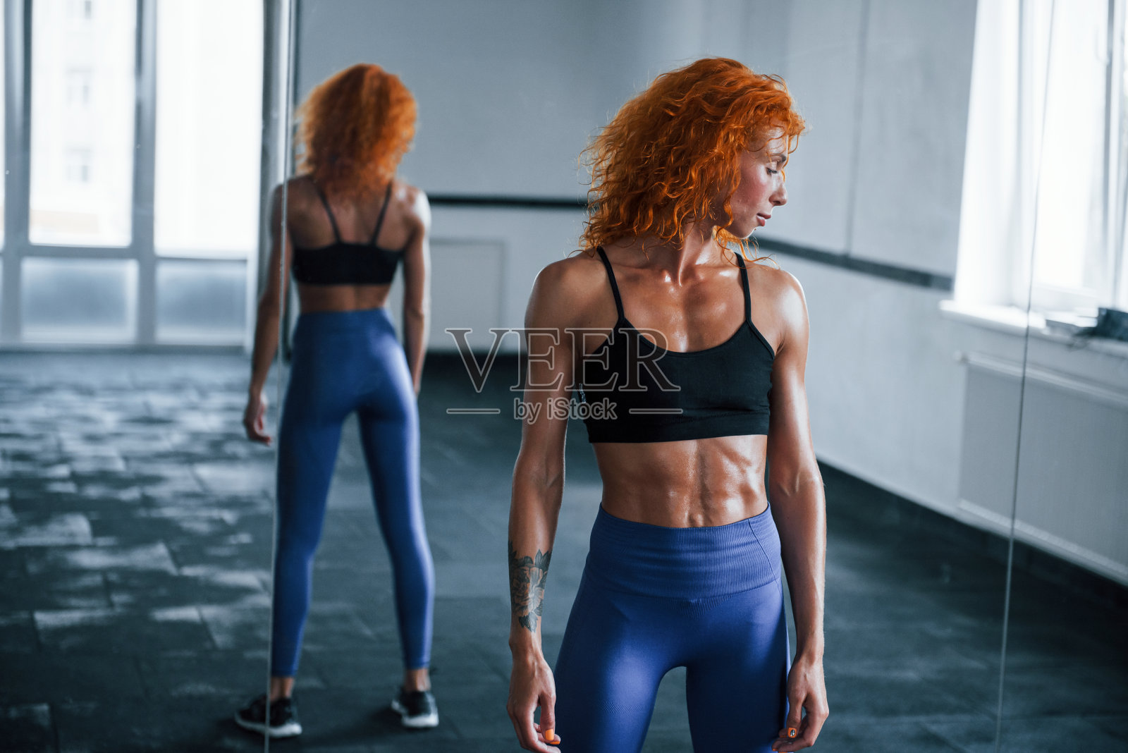 喜欢运动的红发女孩白天去健身房健身。肌肉发达的身体类型照片摄影图片
