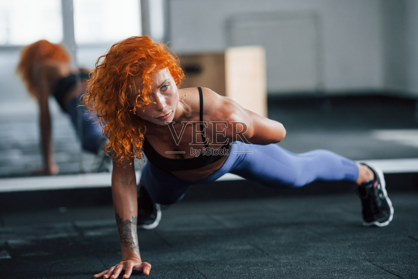 强度和灵活性。喜欢运动的红发女孩白天去健身房健身。肌肉发达的身体类型照片摄影图片