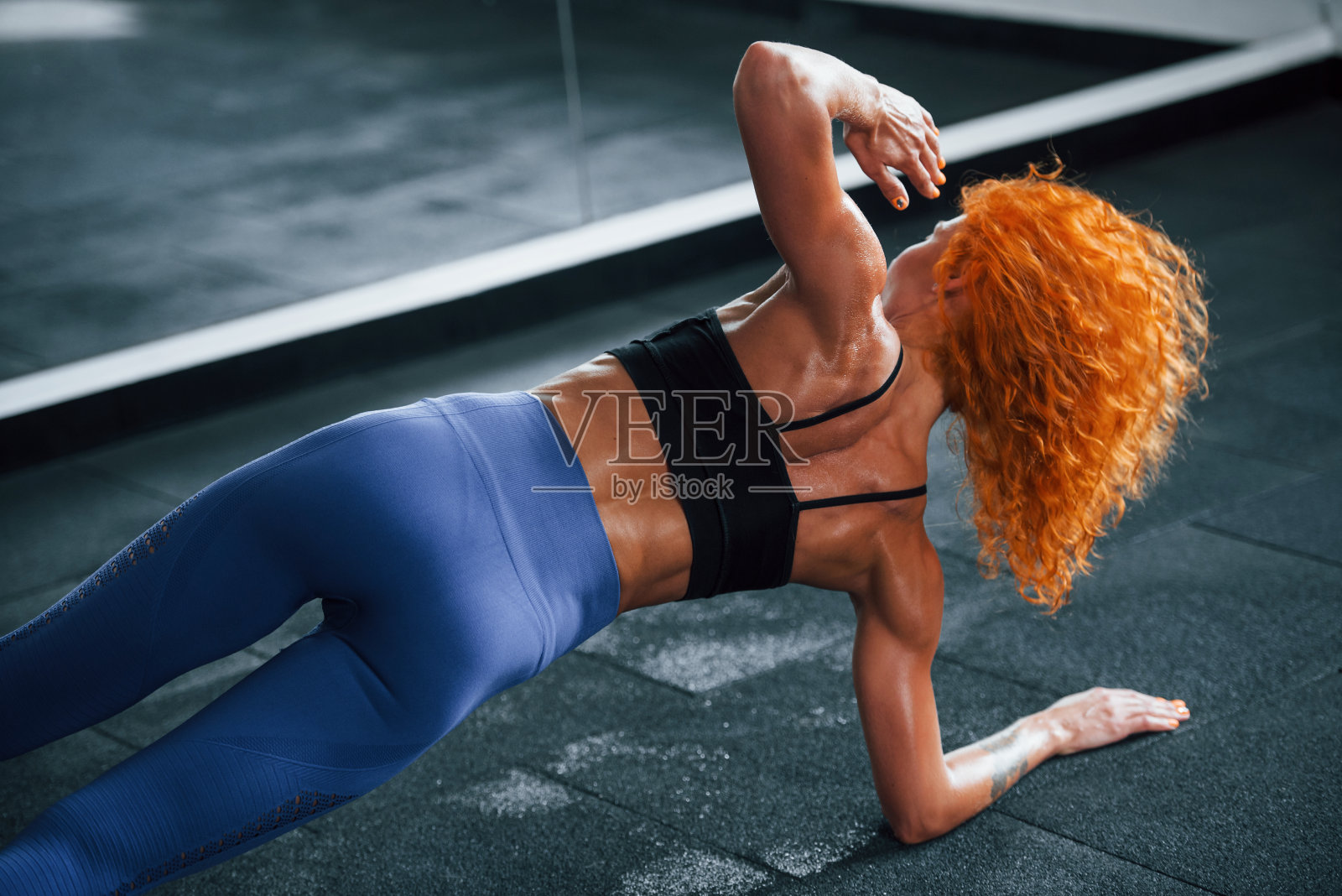 喜欢运动的红发女孩白天去健身房健身。肌肉发达的身体类型照片摄影图片