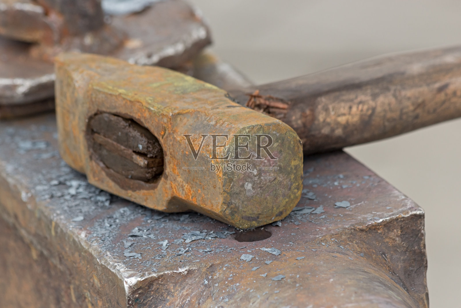 生锈的旧锤子放在铁砧上。照片摄影图片