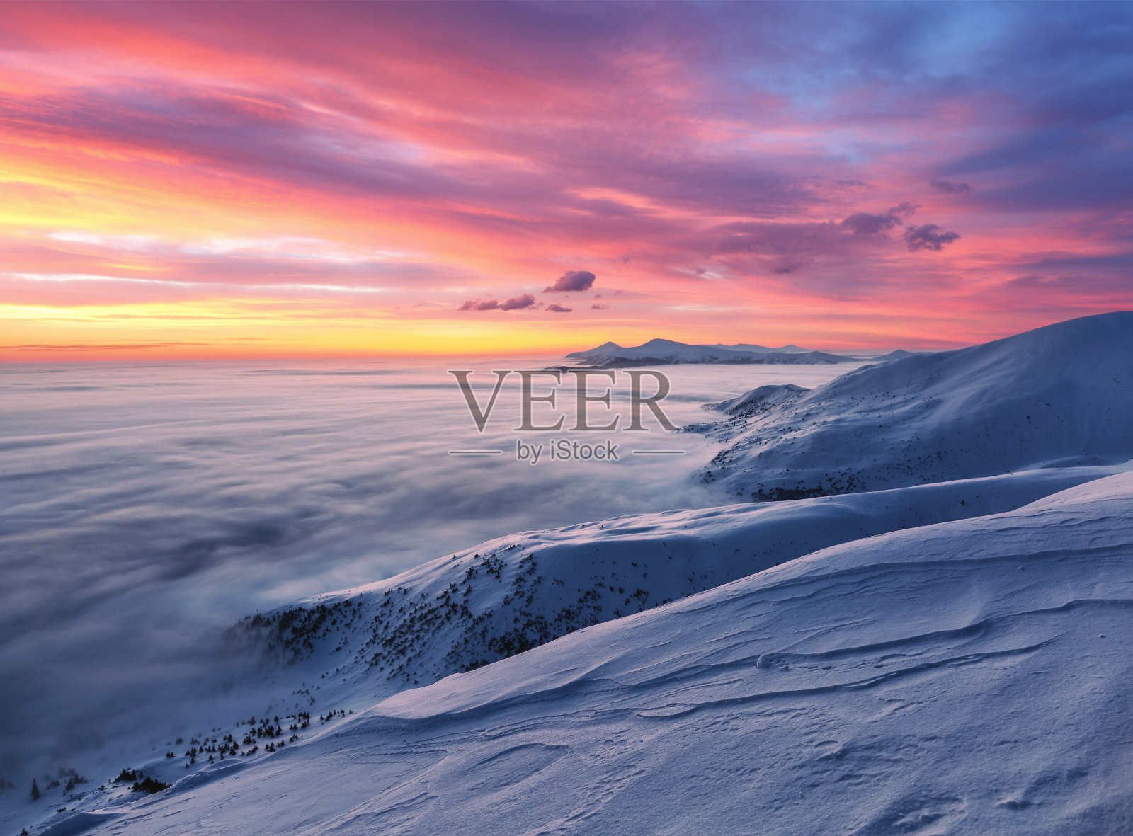 壮丽的天空和粉红色的云。奇妙的日出照亮了高山、浓雾和地平线。下雪的冬天的早晨。壁纸背景。地点:欧洲，乌克兰，喀尔巴阡。照片摄影图片