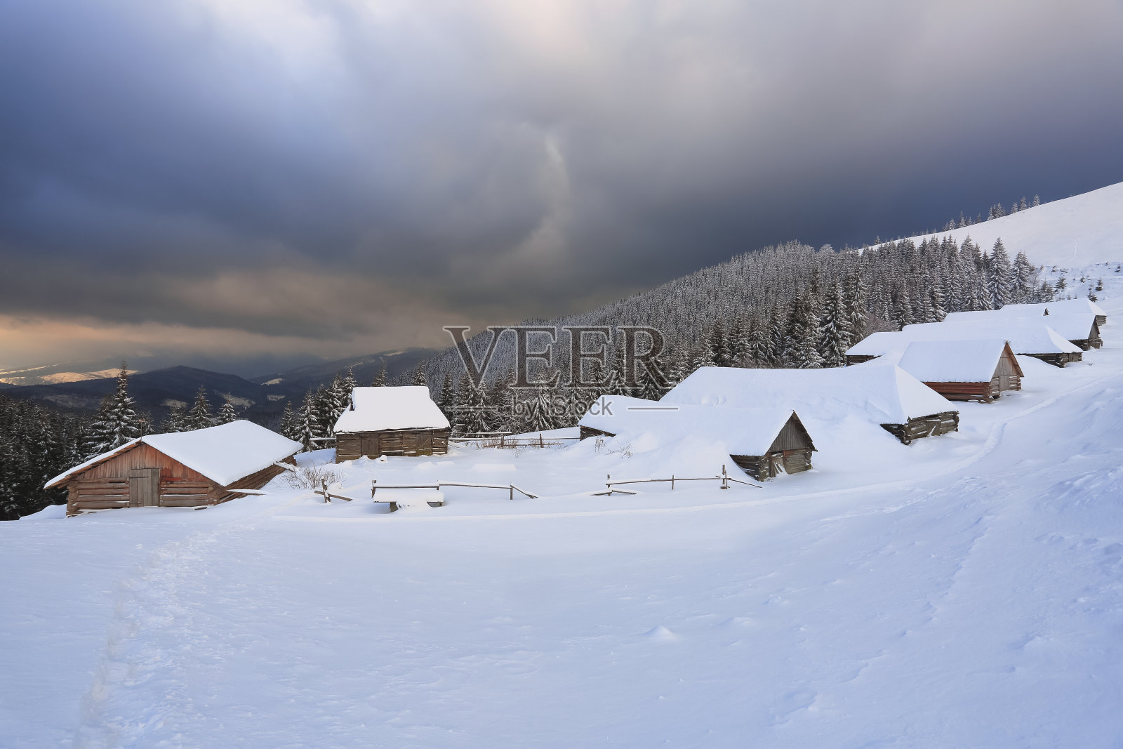 雄伟的冬季景色。戏剧性的天空。覆盖着积雪的草坪上的旧木屋。高山和森林景观。壁纸背景。地点:欧洲，乌克兰，喀尔巴阡。照片摄影图片