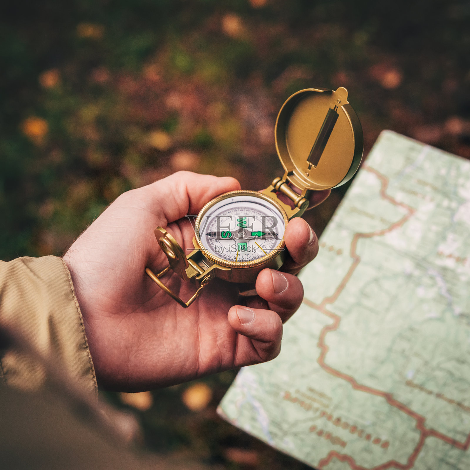 一个人拿着一个指南针和一张纸地图在他的手和引导的地区，秋天森林，散步，徒步旅行照片摄影图片