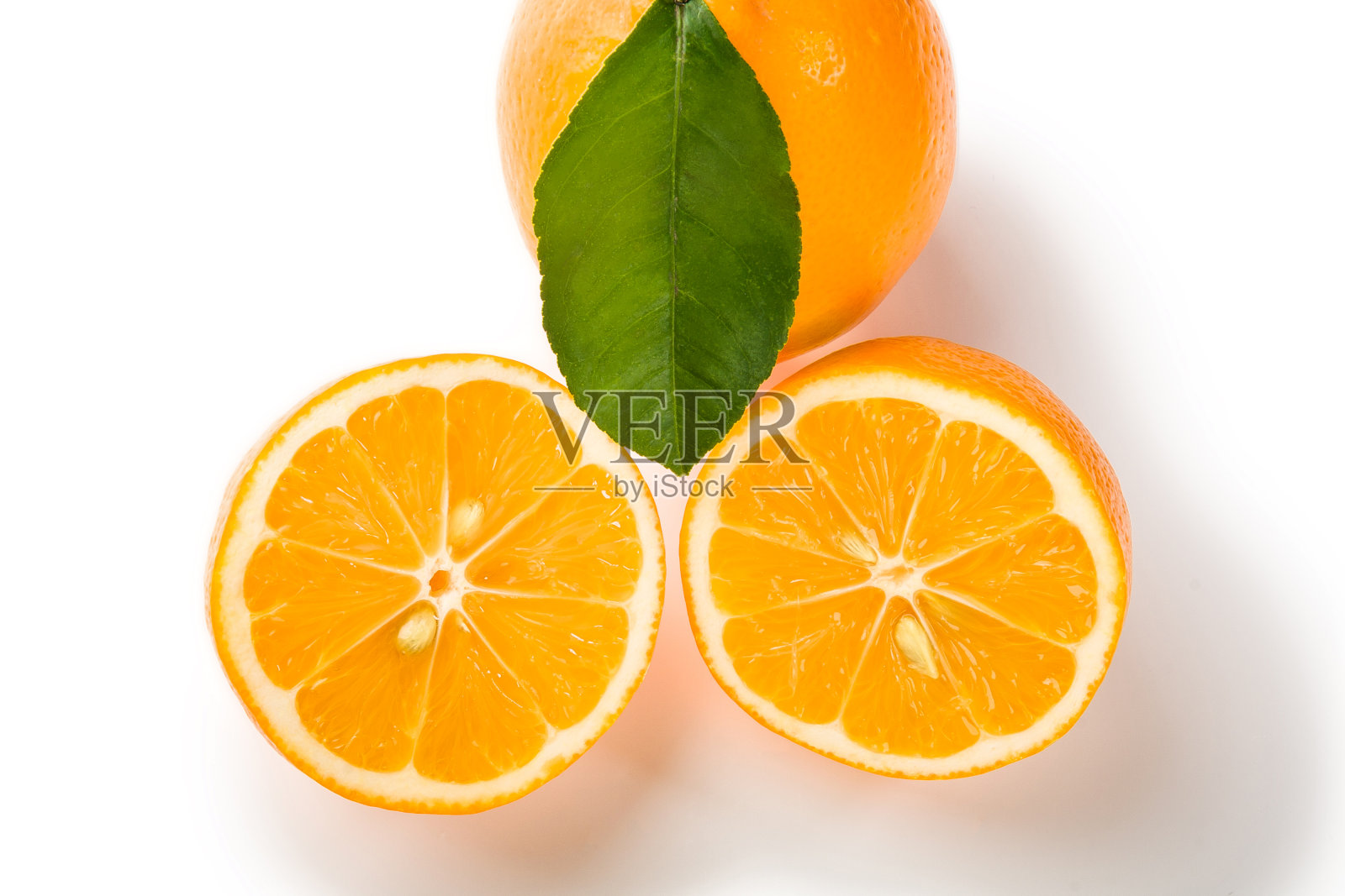 把柠檬切成两半，叶子放在白色的背景上照片摄影图片