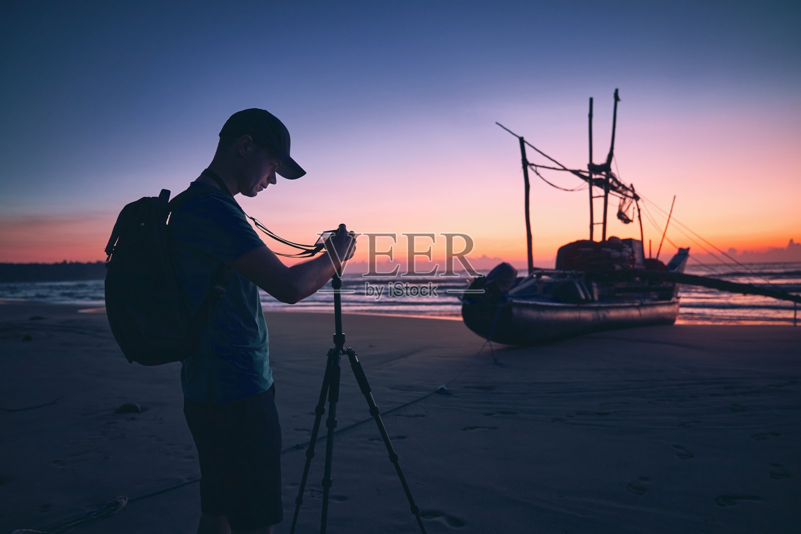 在美丽的日出海滩上的摄影师照片摄影图片