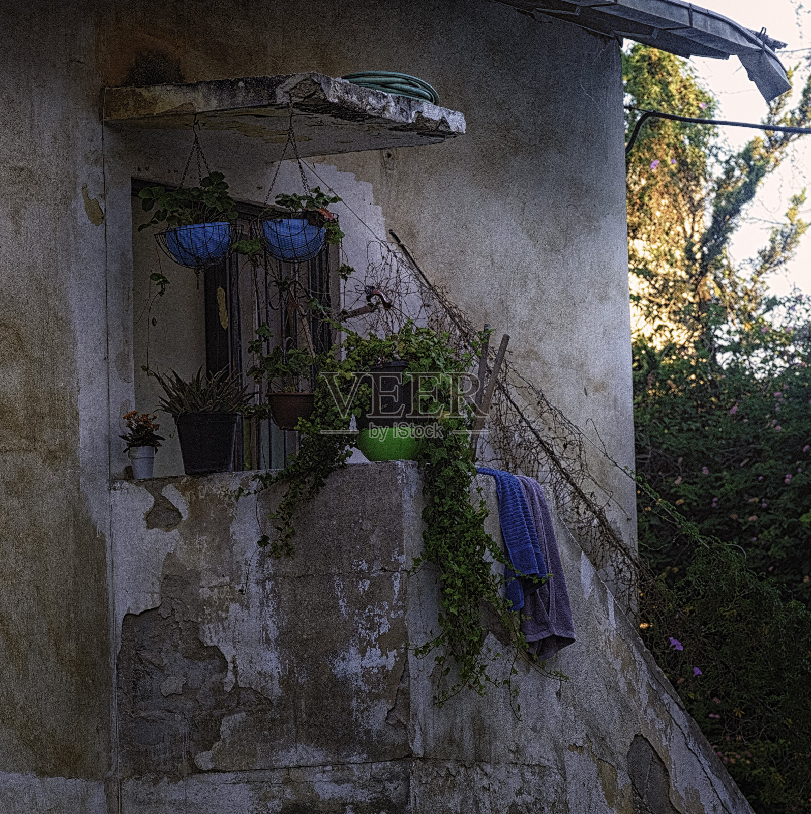 阳台上有花盆、花和毛巾。典型的地中海老房子。照片摄影图片