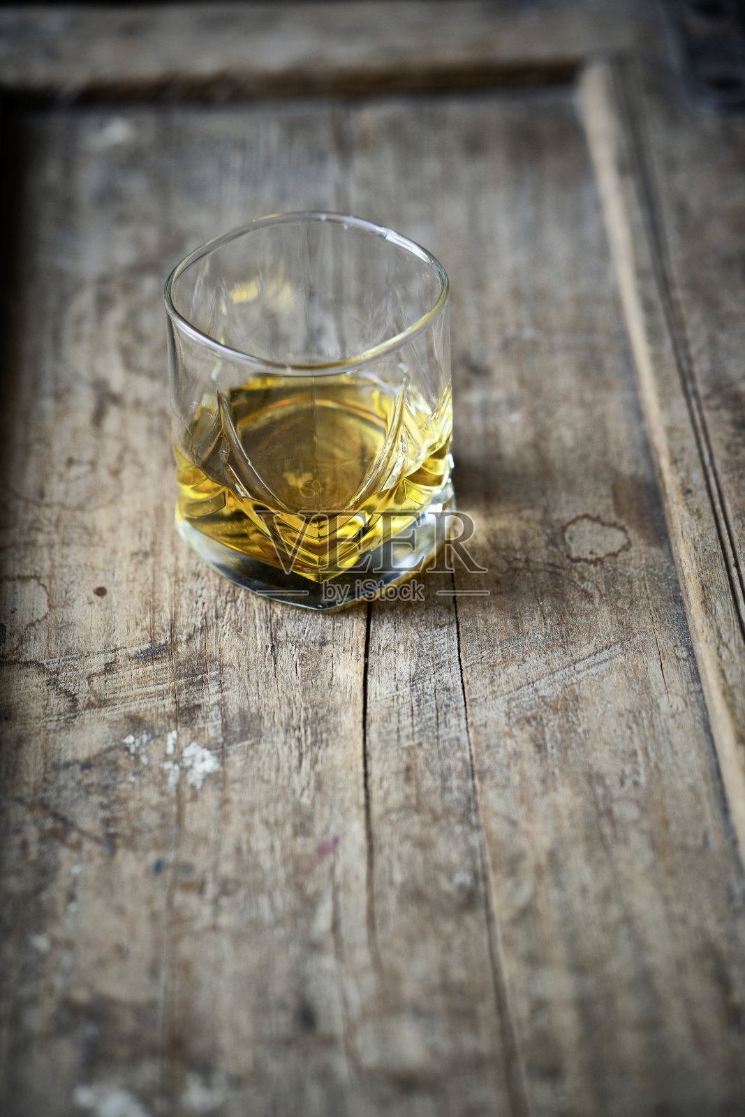 威士忌酒杯放在破旧的木头桌子上照片摄影图片