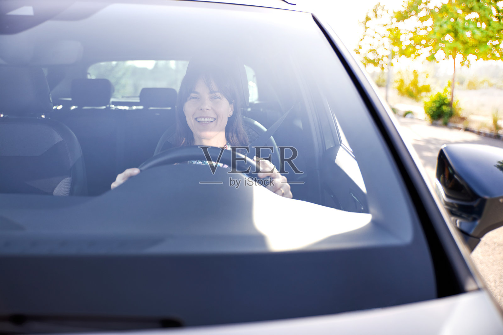 美丽快乐微笑的女人开着她的新车照片摄影图片