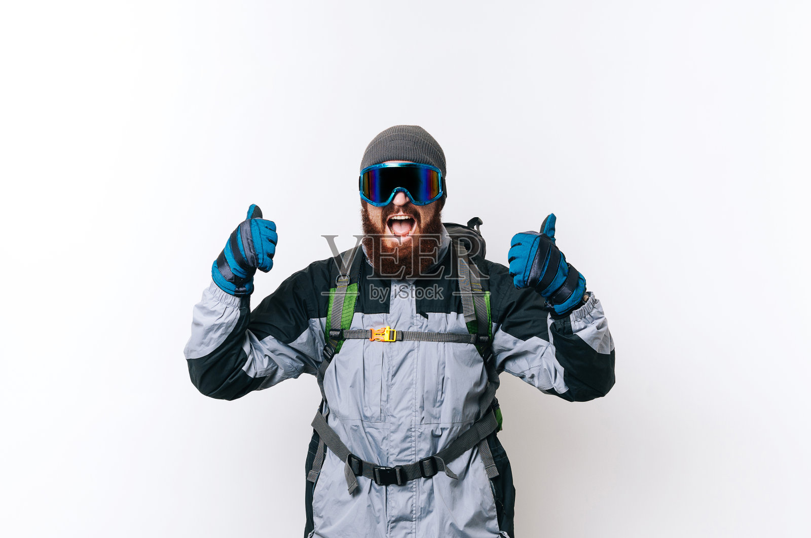 一名蓄着胡须的兴奋徒步者用冬季装备竖起大拇指，准备登山旅行照片摄影图片