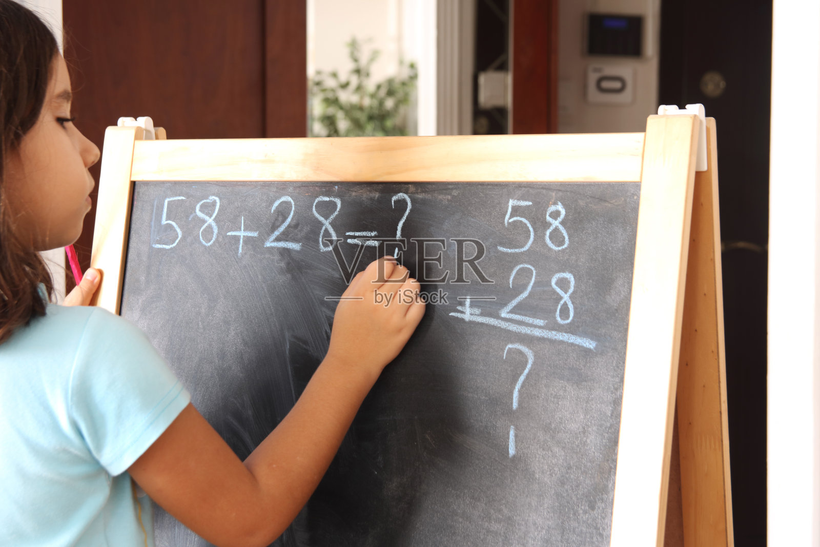 小女孩在黑板上写数学运算照片摄影图片