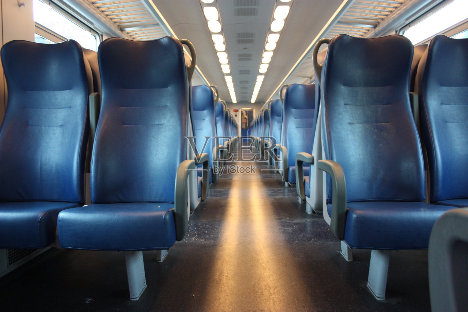 在托斯卡纳，一列白天没有乘客的区域列车的走廊上排着蓝色的座位照片摄影图片
