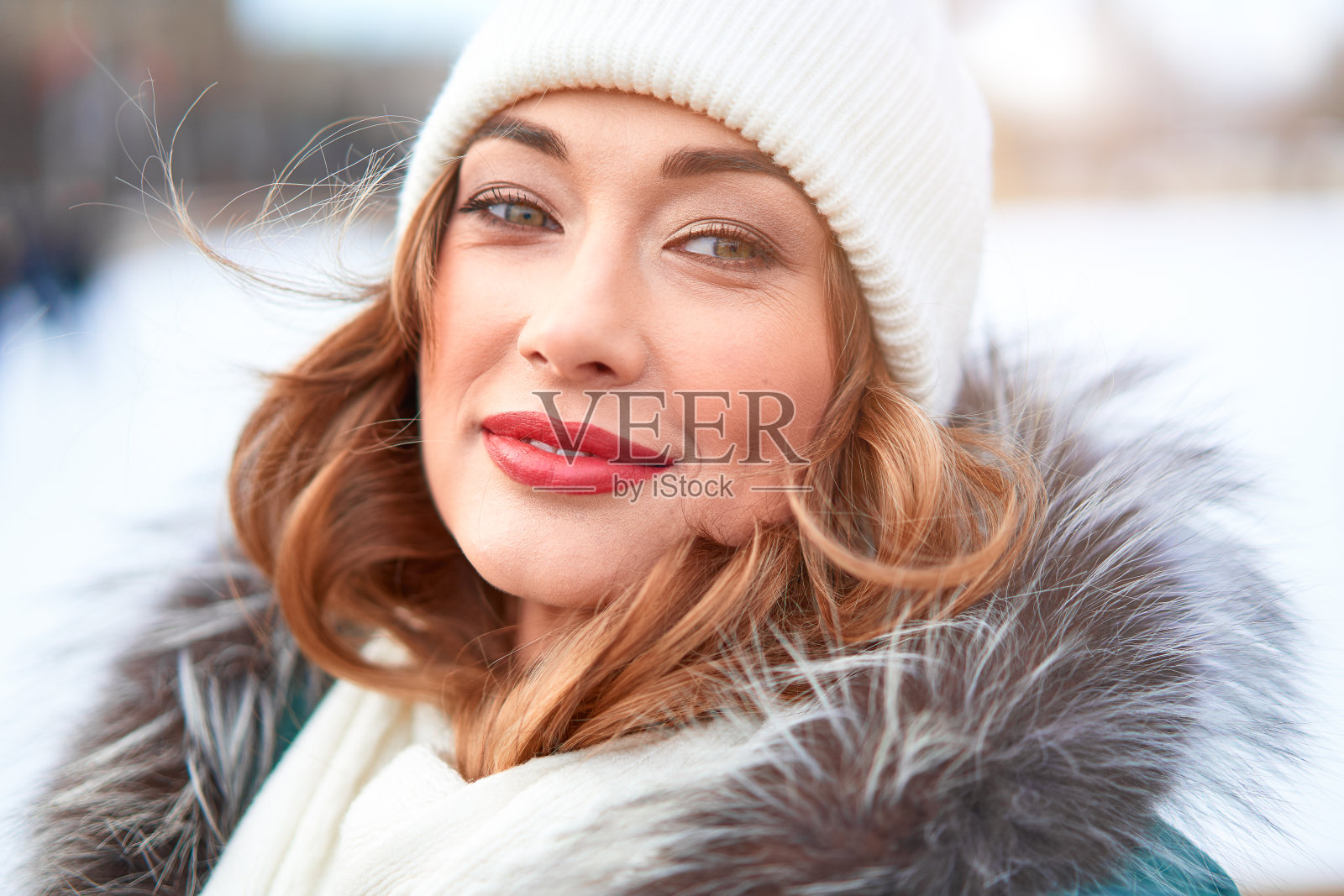 美丽可爱的中年女孩，卷着头发，穿着暖和的冬衣，站在冰场的背景镇广场上。照片摄影图片