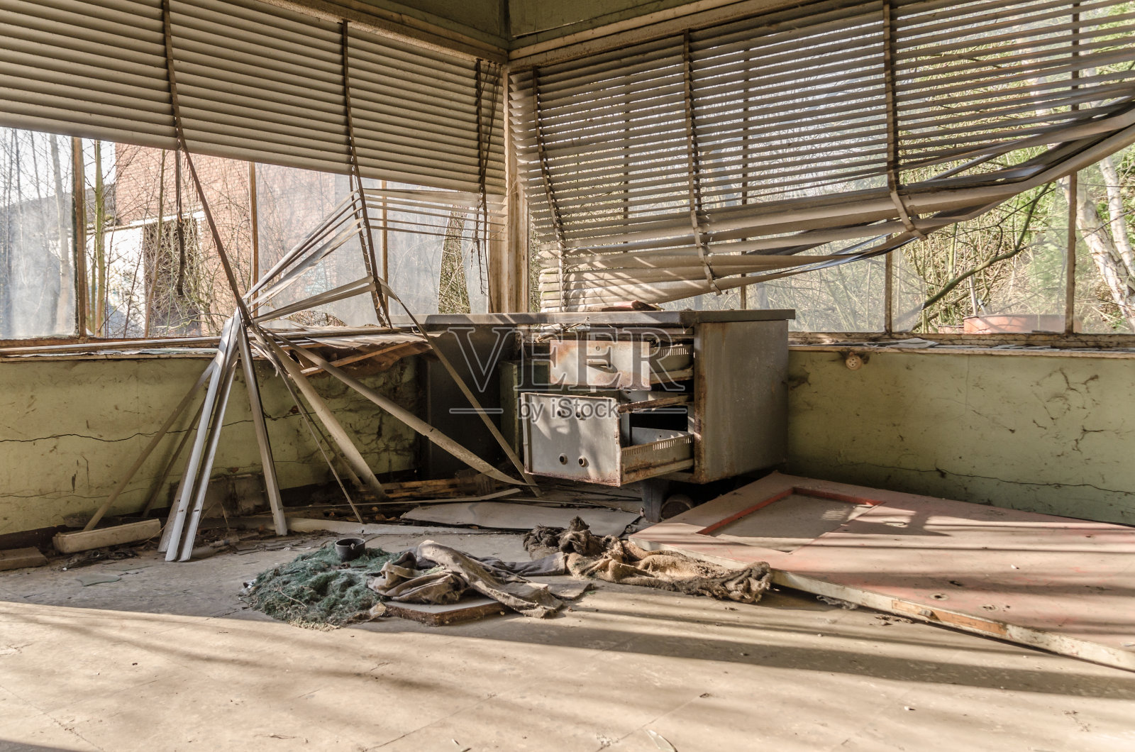 一张被废弃的、被破坏的桌子，钢制的桌子和垂下来的百叶窗照片摄影图片