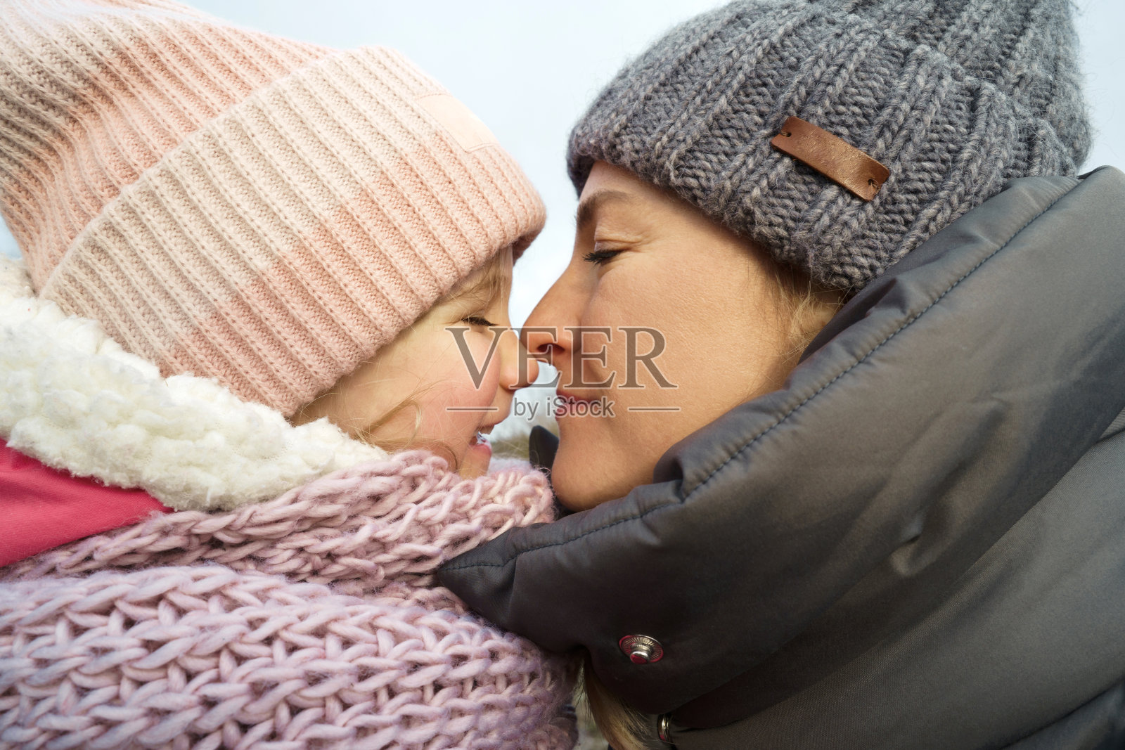 四岁的女儿和母亲都有暖和的冬衣，帽子和围巾照片摄影图片