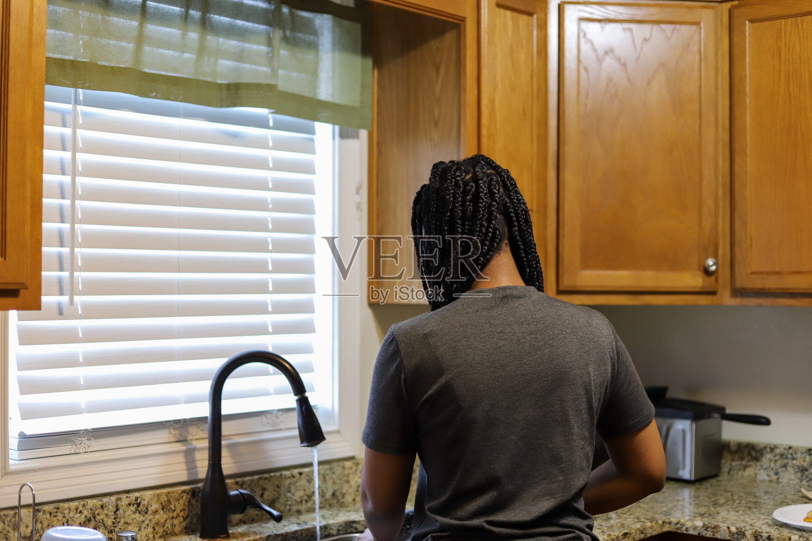 一个非洲裔美国少女在家里洗碗的照片照片摄影图片
