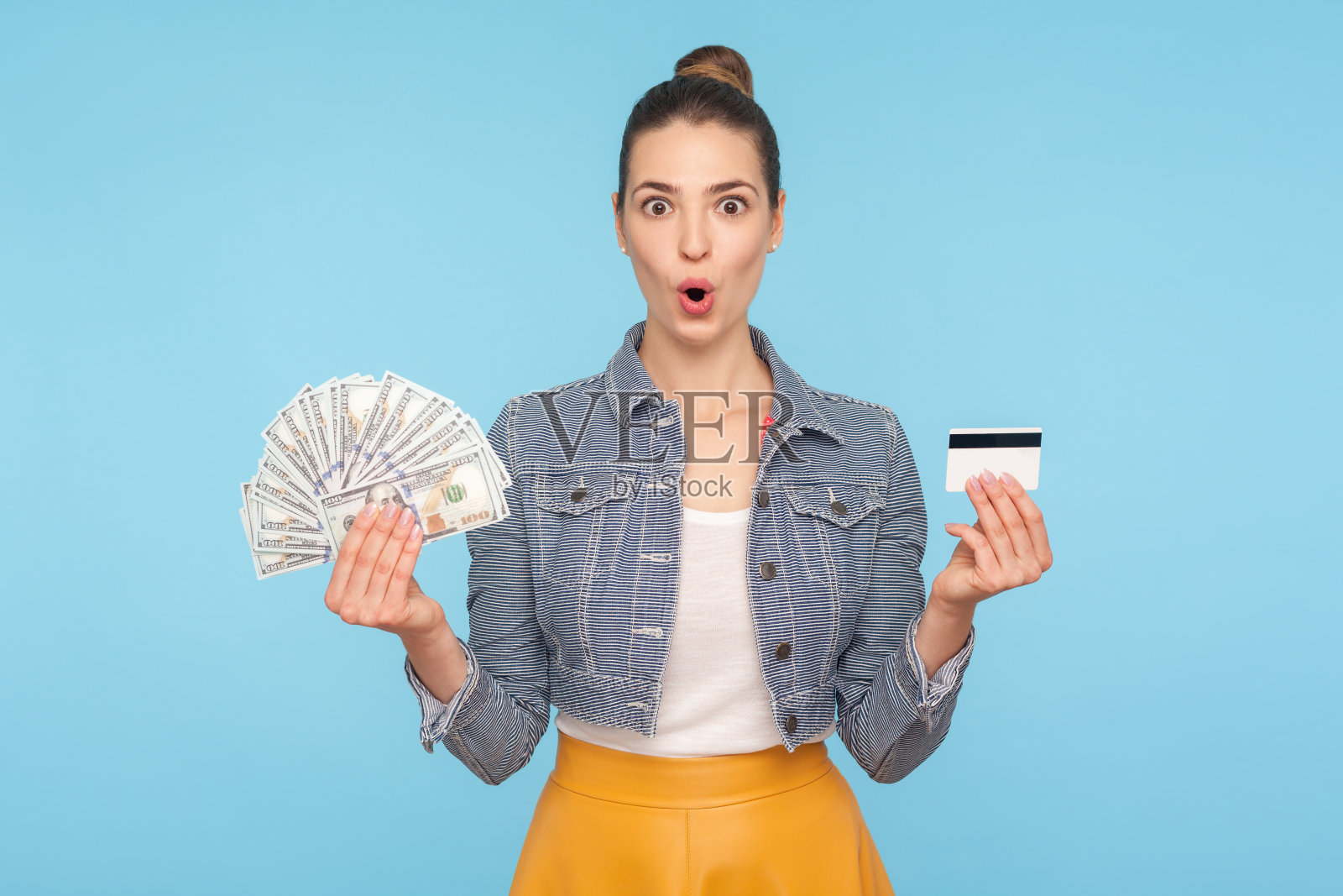 哇,高息贷款!高兴和惊讶的女人的肖像持有信用卡和美元钞票照片摄影图片