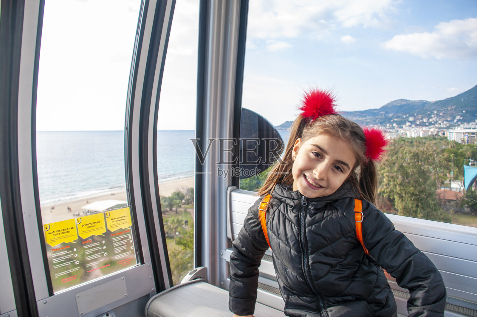 可爱的女孩在缆车上的肖像与城市景观照片摄影图片