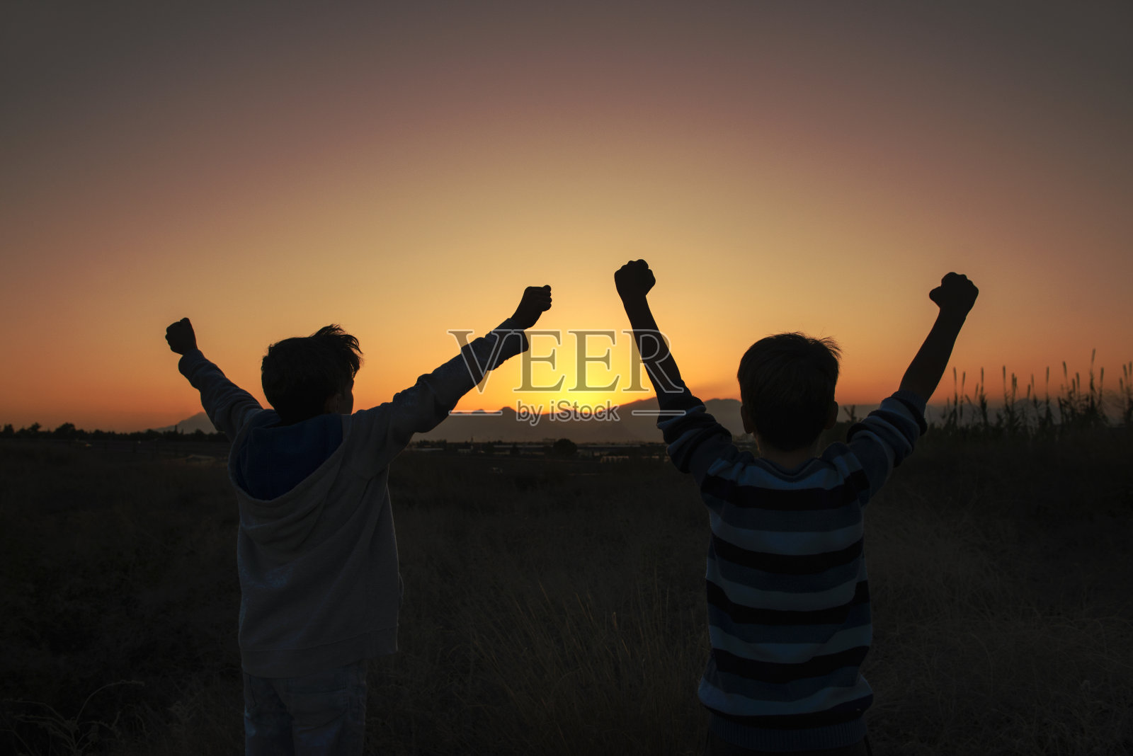 这是两个快乐的朋友在乡村的夕阳下欢呼的照片照片摄影图片