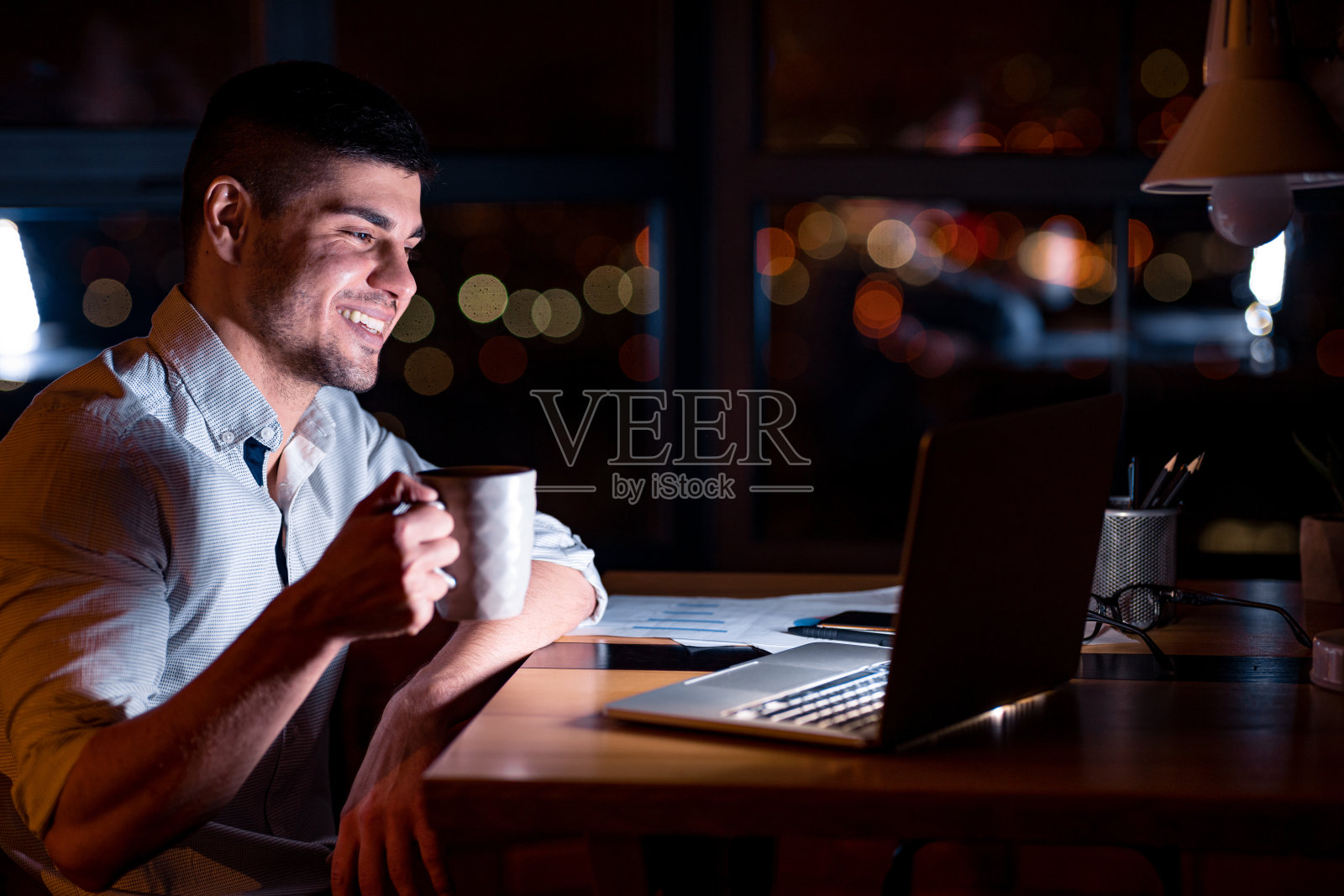在工作场所用笔记本电脑喝咖啡的商人照片摄影图片