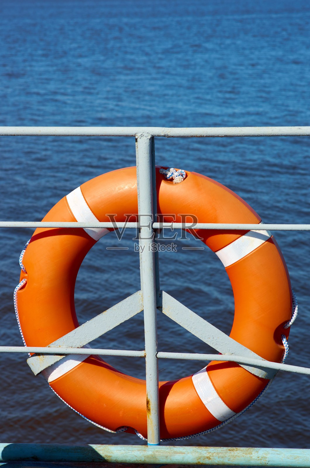 船栏杆和红色的生活圈前景，蓝色的大海背景照片摄影图片