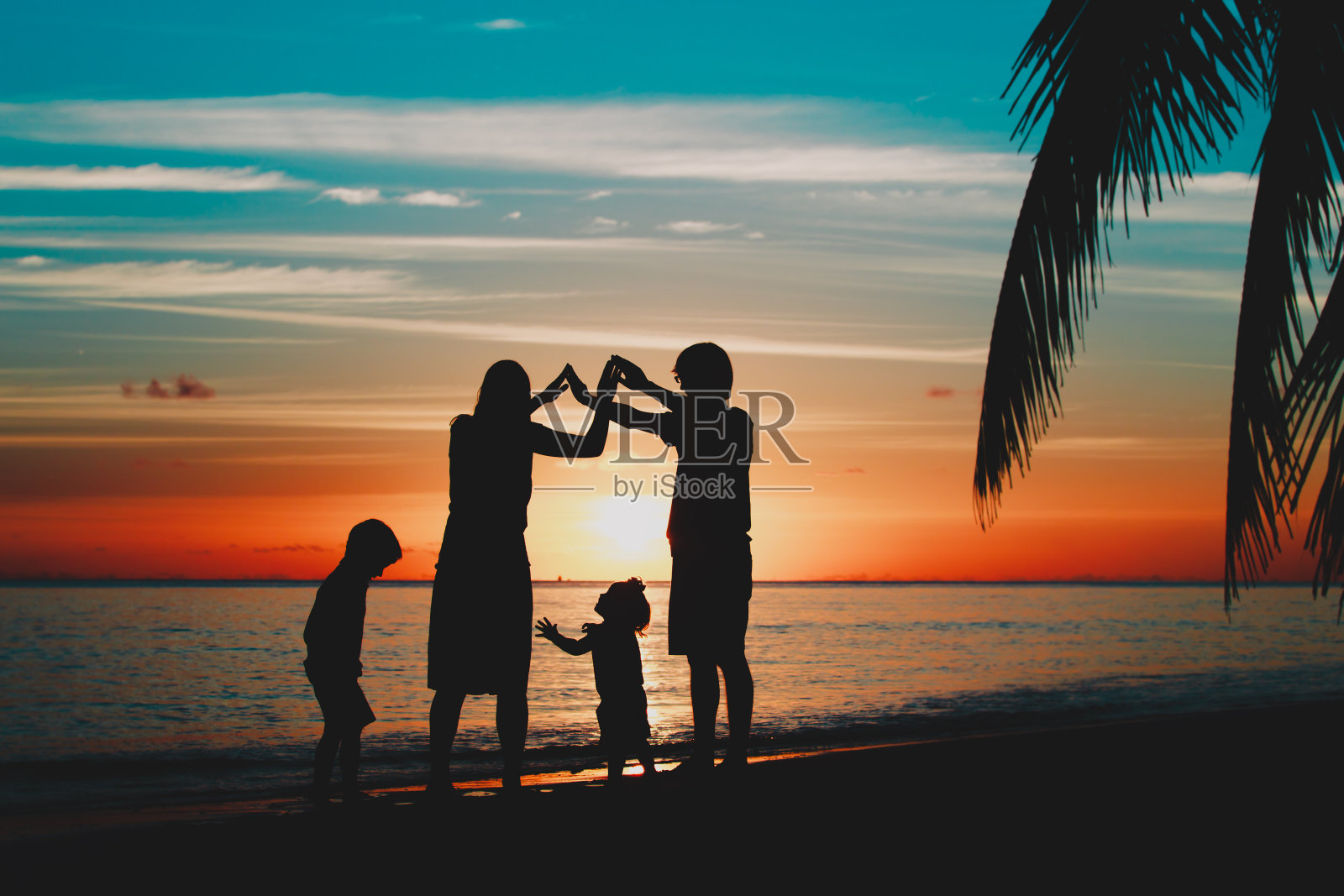 幸福的家庭和孩子们在日落海滩上玩耍照片摄影图片