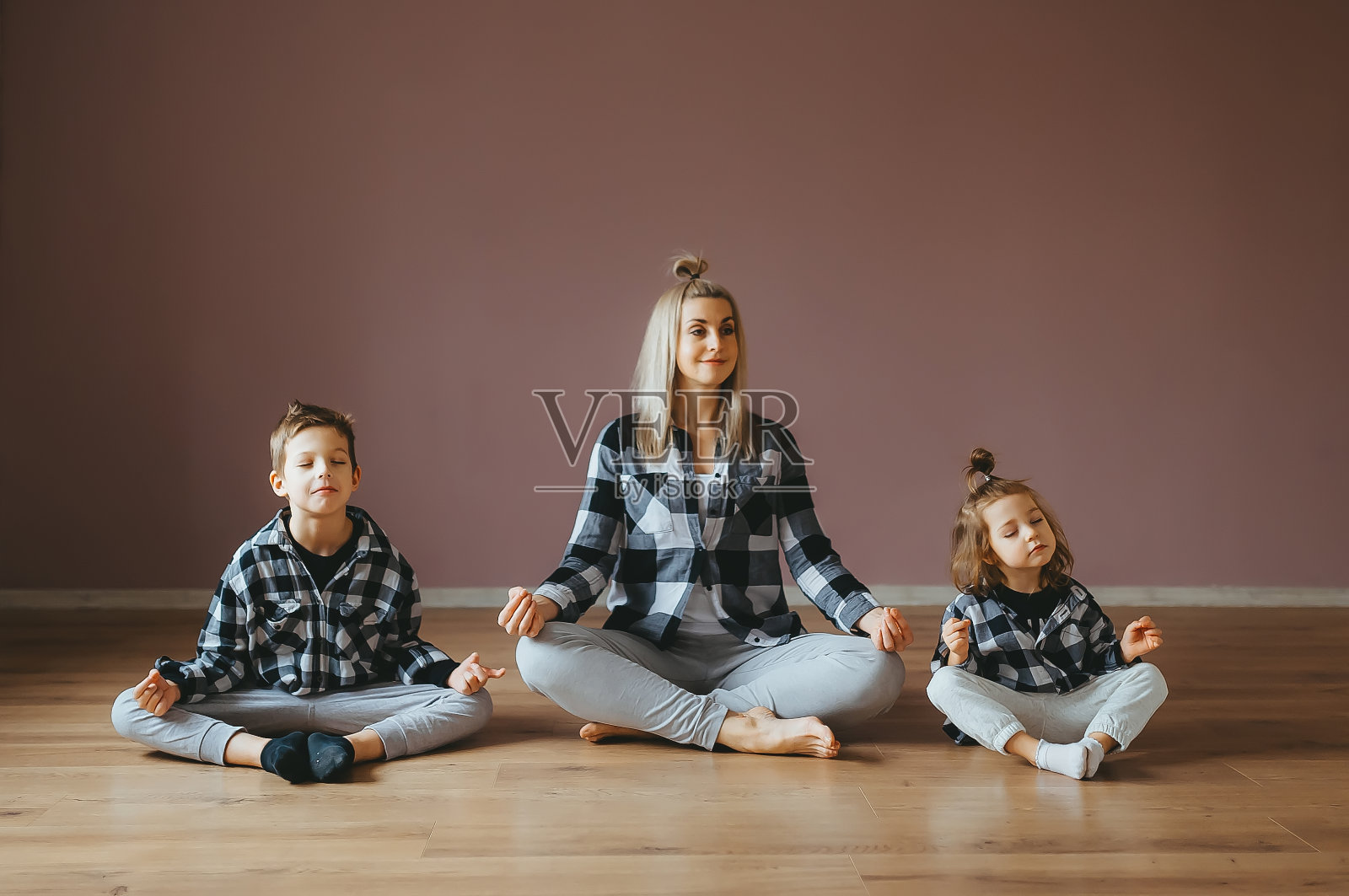 年轻家庭的母子儿女都在练瑜伽，在健身房锻炼。照片摄影图片