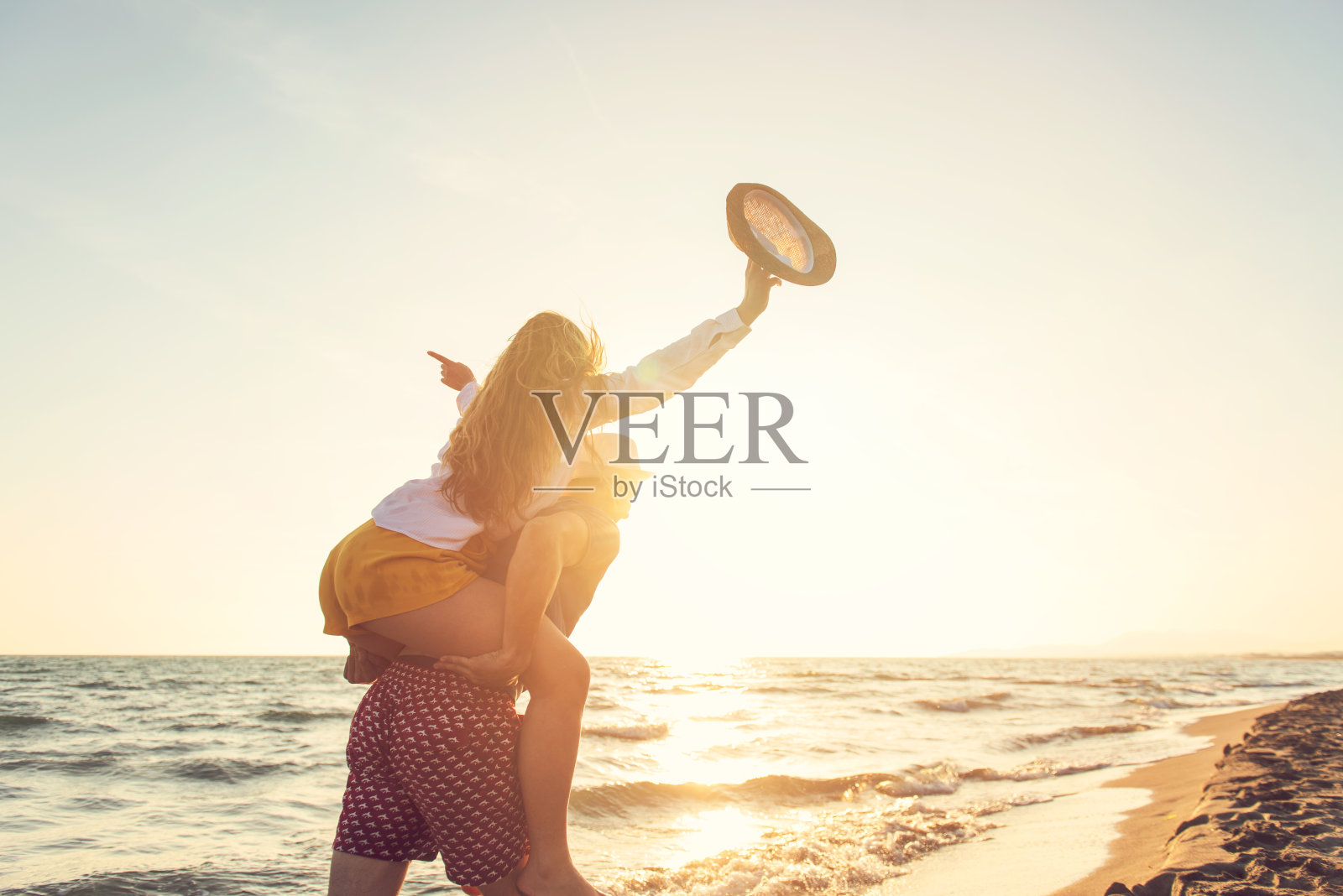 快乐浪漫的中年夫妇享受美丽的日落漫步在海滩上。旅游度假退休生活理念照片摄影图片