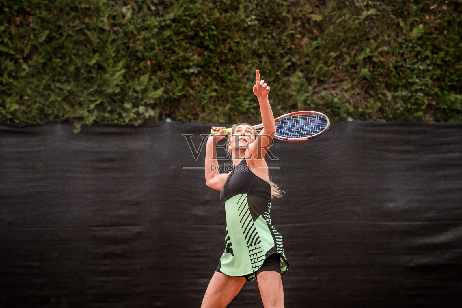 休闲女网球运动员发球照片摄影图片